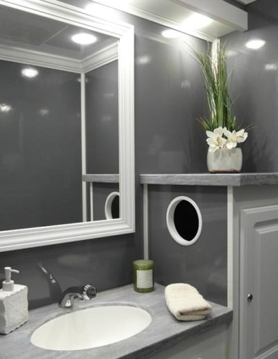 Port-A-Lisa 2-Station Restroom Trailer with a flushable sink, mirror, and cabinets.