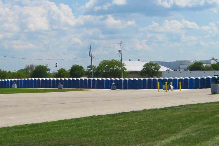 The Weekender portable restrooms and 2-Sided Hand Wash Stations are lined up and ready for a large outdoor event.