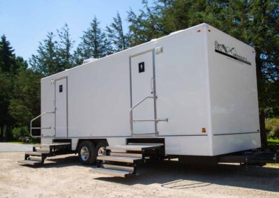 The Ruby Luxury 7-Station trailer stationed outside by a forest.